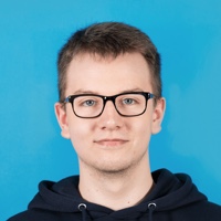 Portr&auml;t von Luca Albrecht, der in die Kamera blickt und dabei l&auml;chelt; vor einem hellblauen Hintergrund.